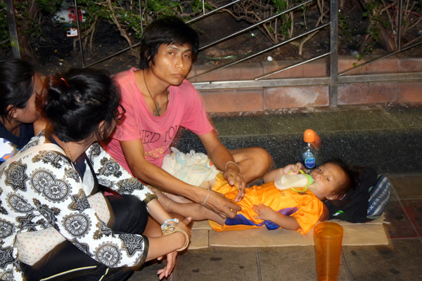 Chanarang tends his daughter, 6, near the capital's Soi Cowboy red light district. He he wants to take her home to Nakhon Lampang, but said he cannot earn enough money to support them.