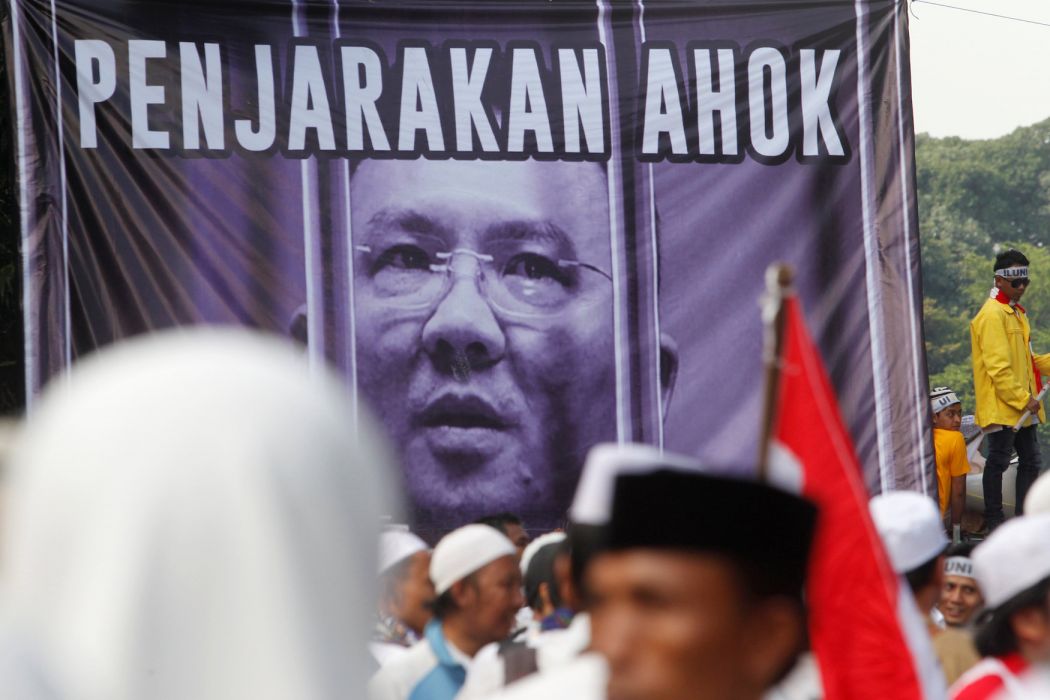 Indonesian protesters chant in front of a poster of Basuki Tjahaja Purnama, known by his nickname Ahok, as they march down the capital city’s main street after a demonstration at Jakarta’s National Monument Park on December 2, 2016. More than 100,000 Indonesian Muslims protested on December 2 against Jakarta’s Christian governor, the second major demonstration in a matter of weeks as conservative groups push for his arrest on accusations of insulting Islam.
GOH CHAI HIN / AFP