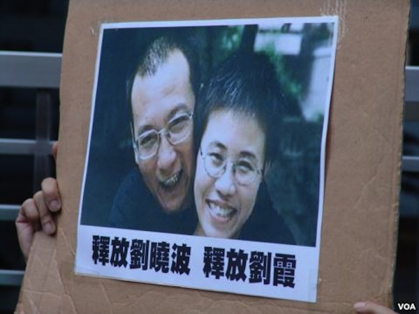 A protester holds up a photo of deceased dissident Liu Xiaobo and his wife Liu Xia at a rally in this undated photo.