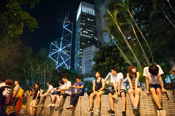 Occupy Central Hong Kong protesters sitting  on wall 