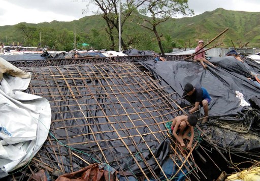 Rohingya refugee children fix the damaged roof of a hut in a makeshift camp in Bangladesh’s Cox’s Bazar district on May 30, 2017 after Cyclone Mora made landfall in the region. Photo: AFP