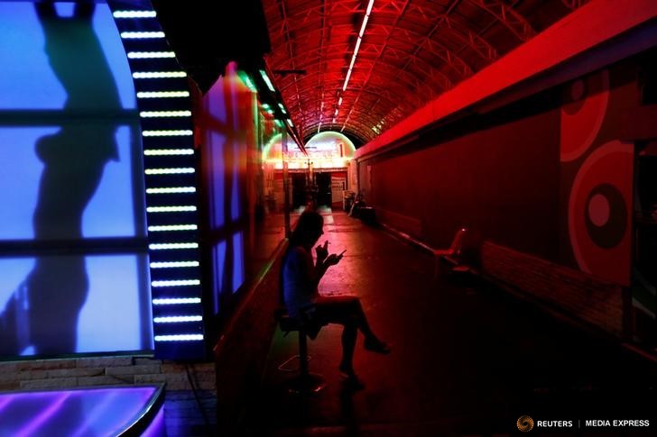 A woman sits outside a go-go dance bar in Pattaya, Thailand March 25, 2017. Photo: REUTERS/Jorge Silva