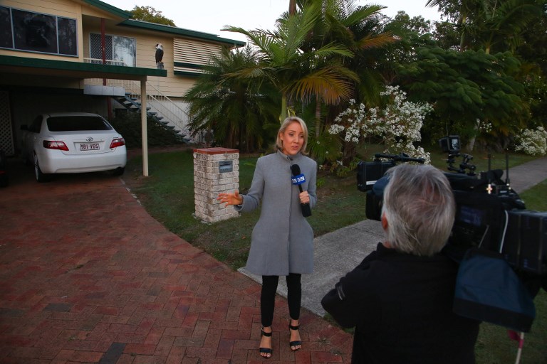 A television reporter does a live report while waiting for the return of Schapelle Corby to her mother’s home in Loganlea on May 28, 2017. 
Australian Schapelle Corby returned home on May 28 following her deportation from Bali 12 years after her conviction for drug trafficking, as she battled through a media storm in a dramatic end to a saga that captivated her homeland. AFP PHOTO / PATRICK HAMILTON