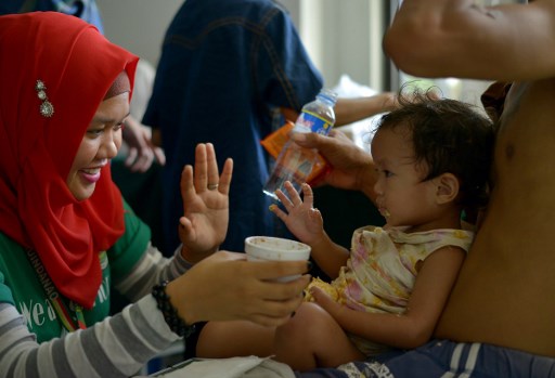 A volunteer doctor feeds 2 years old Manequin Lasola who was trapped for 11 days with her father Julio Lasola at Pangarungan Village in Marawi City, on the southern island of Mindanao on June 3, 2017. 
Philippine troops battle Islamists in the southern city of Marawi, with nearly two weeks of clashes claiming at least 175 lives. / AFP PHOTO / RODY
