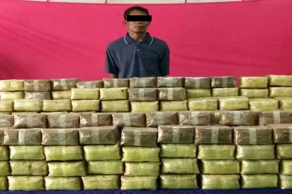 Aung Saw Than with the 340 10,000 tablet packets he was paid to transport. Photo: State Counsellor Office Information Committee