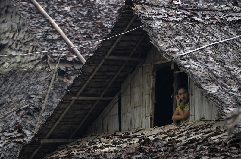 A refugee watches from her stilt house at Mae La refugee camp, Tak province, July 21, 2014. Photo: Chaiwat Subprasom/ Reuters