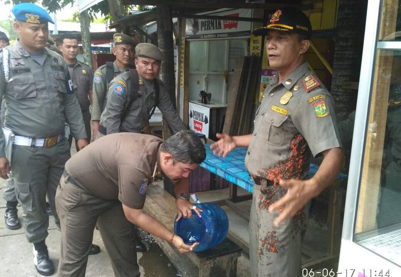 Satpoll PP officers in Riau after having sambal (chili sauce) thrown at them by an irate eatery owner. Photo: Satpol PP Kampar