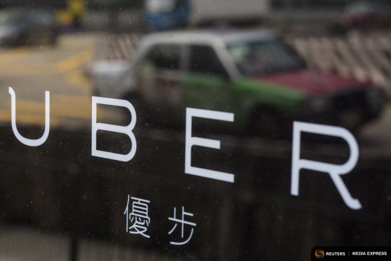 A taxi is reflected in a window at the office of taxi-hailing service Uber Inc. in Hong Kong, August 12, 2015.   File photo: Tyrone Siu/Reuters