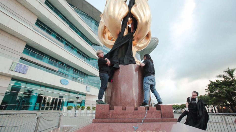 Activists from Demosisto drape a black flag on the Golden Bauhinia statue in Wan Chai on June 26, 2017. Photo: Jimmy Lam/Demosisto via Facebook