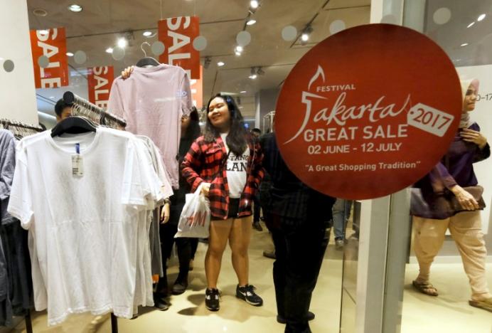 A customer holds a shirt during late night Ramadan shopping at Gandaria City Mall in Jakarta, Indonesia, June 10, 2017.   REUTERS/Beawiharta