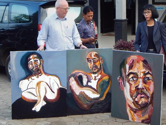 Lawyers Julian McMahon (L) and Veronica Haccou (R) display three self-portrait paintings made by Australian death row prisoner Myuran Sukumaran in Cilacap after visiting Nusakambangan maximum security prison island located off central Java on April 25, 2015. Photo: Azka/AFP