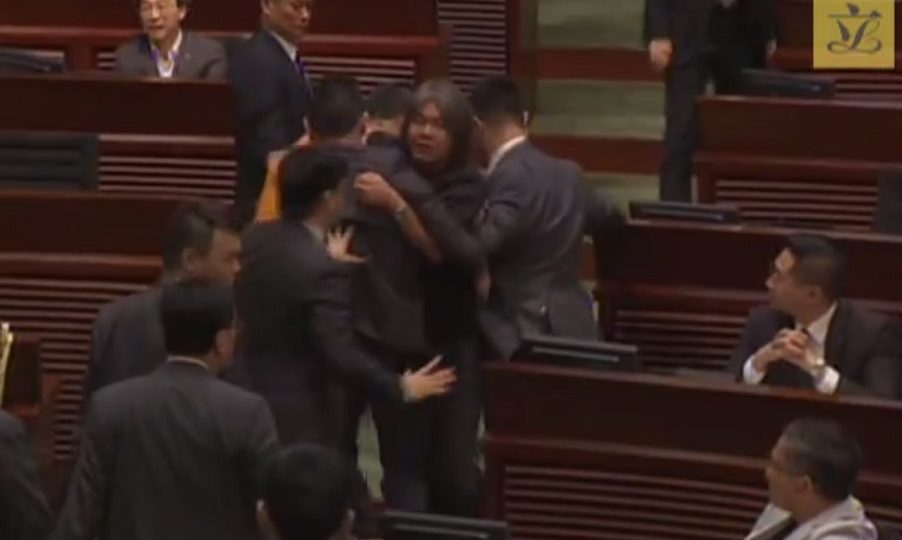 Democratic lawmaker “Long Hair” Leung Kwok-hung was forcibly removed from the legislative chamber by security guards after he threw paper at Chief Executive CY Leung. Screenshot: Legislative Council via Youtube
