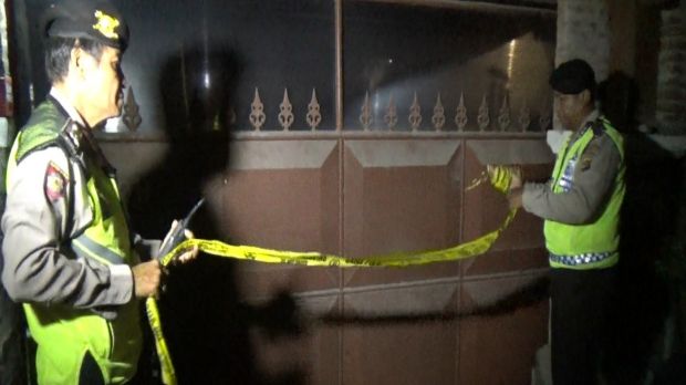 Police set up tape outside of the rented Sanur villa where the victim had been staying.