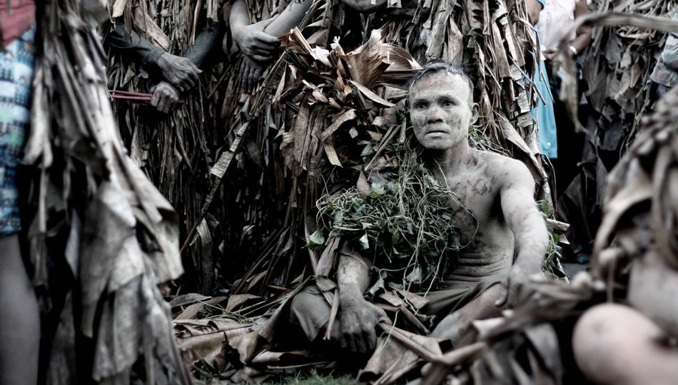 A man is covered in dried leaves and mud in celebration of the feast of St. John the Baptist in the Philippines. PHOTO: ABS-CBN News
