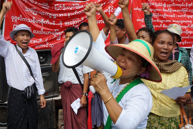 A demonstrator shouts into a megaphone during a protest in Mandalay, in Central Myanmar on July 12, 2017. / AFP PHOTO / Kway Zay Win