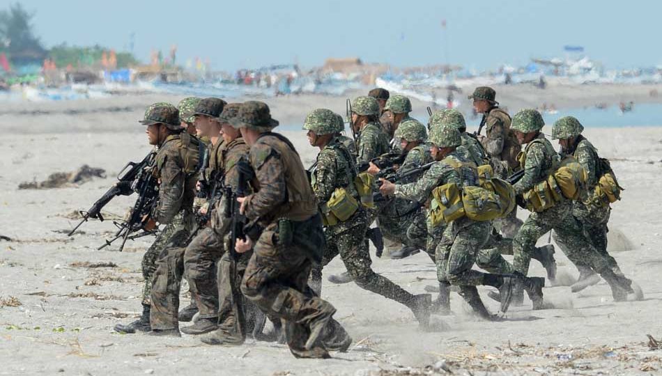 Philippine and US marines take their positions during a beach assault exercise facing the South China sea in San Antonio town, Zambales province on May 9, 2014. Scores of US and Filipino marines launched mock assaults on a South China Sea beach in the Philippines on May 9 in war games aimed at honing the allies’ combat skills. AFP PHOTO/TED ALJIBE
