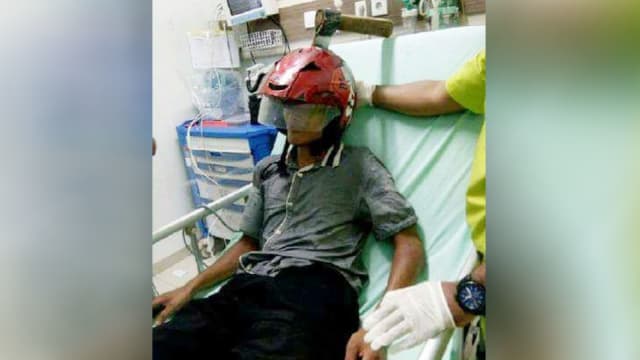 Inches from possible death: An axe lodged into a motorcyclist’s helmet in Indonesia. Photo: Facebook
