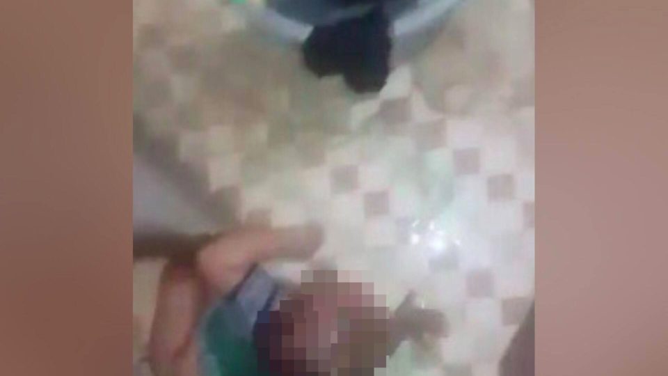 A still from a distressing video posted to Facebook, showing a mother dousing her baby with dish soap. 
