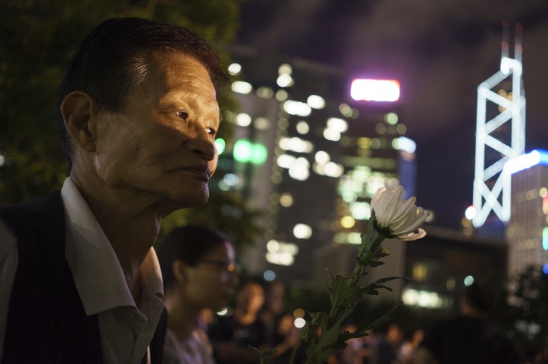 A man holds a white flower at a memorial event for the late Chinese Nobel laureate Liu Xiaobo in Hong Kong on July 19, 2017.
Hundreds turned out in Hong Kong to pay their respects. AFP PHOTO / Aaron Tam