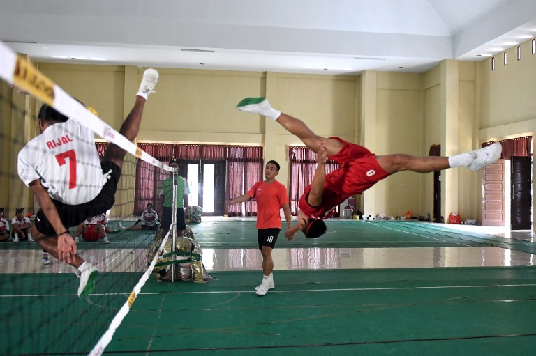 This photo taken on May 22, 2017 shows a member of Indonesia’s national sepak takraw team performing an overhead kick to fire a ball over the net during a training session at an elite police force base in Jambi.  Photo: AFP PHOTO / Goh Chai Hin