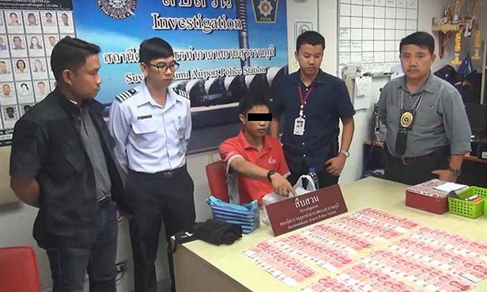 One of the alleged thieves points at stolen money seized from him. Photo: Sanook