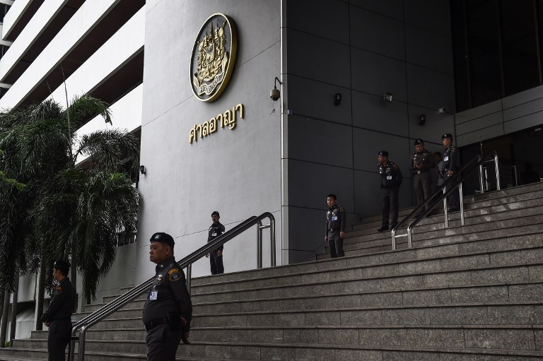 Thai policemen stand guard outside of a criminal court in Bangkok on July 19, 2017. AFP PHOTO / LILLIAN SUWANRUMPHA