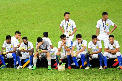 Malasyia’s football team players sit on the podium after losing to Thailand during their men’s football final match of the 29th Southeast Asian Games (SEA Games) at  Shah Alam Stadium, outside Kuala Lumpur on August 29, 2017. / AFP PHOTO / MANAN VATSYAYANA