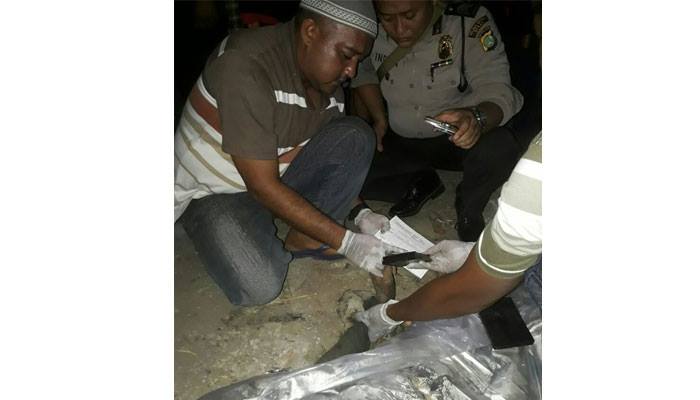 Investigators examining the corpse of MA, who they say was beaten and burned alive by an angry mob after stealing speakers from a mosque. Photo: Bekasi Police / Polda Metro Jaya Dot Info / Facebook 