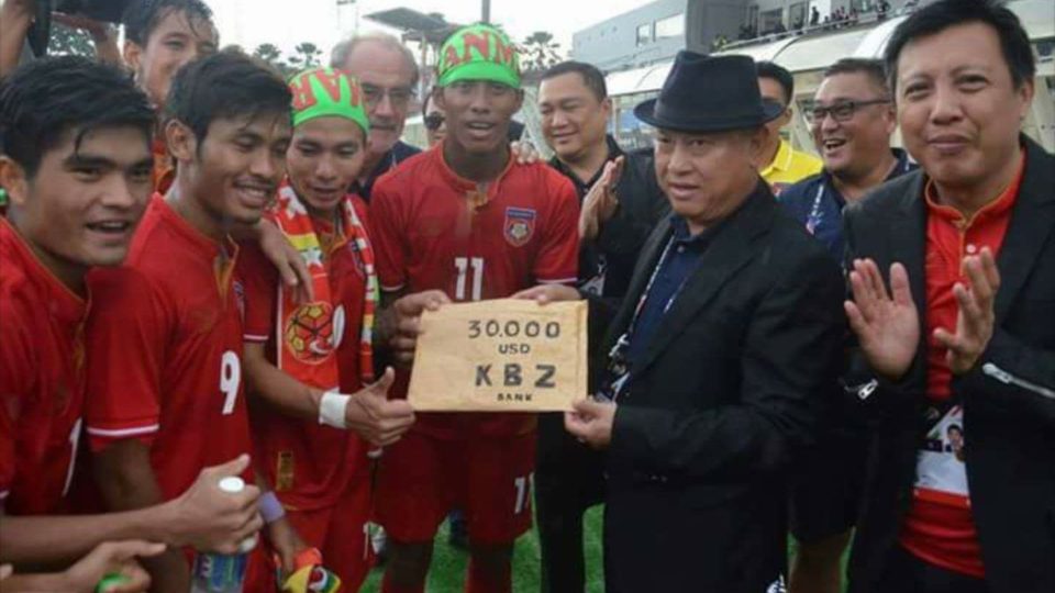 Members of Myanmar’s U-23 football team hold up part of their $50,000 cash prize after beating Singapore 2-0 on Monday. Photo: Facebook / Thai Futbol