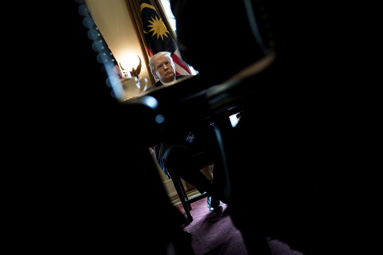US President Donald Trump waits for a meeting with Prime Minister of Malaysia Najib Razak and others in the Cabinet Room of the White House September 12, 2017 in Washington, DC. / AFP PHOTO / Brendan Smialowski