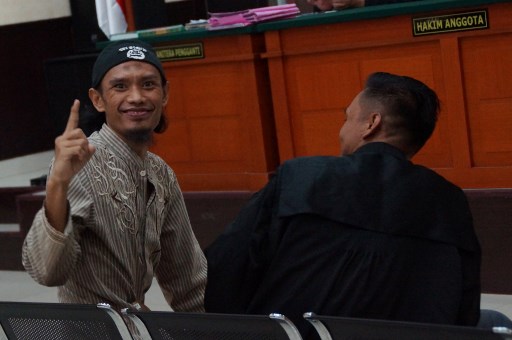 Indonesian Juhanda (L) gestures during his trial in Jakarta on September 25, 2017. AFP PHOTO / ARIE FIRDAUS