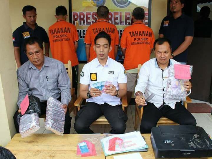 Banjarmasin police at a press conference showing off the fake money printed up by the two arrested teachers. Photo: Polsekta Banjarmasin Tengah 