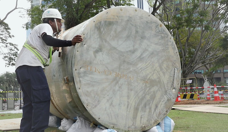 Still of workers examining exhumed time capsule from 1990 prepared when Singapore celebrated 25 years of independence. Photo: In Time to Come