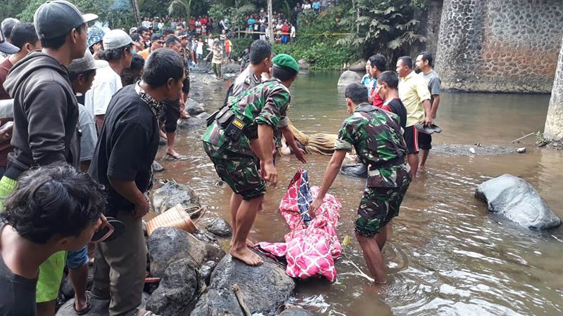 Officials recovering the corpses found in he Purbalingga’s Klawing River yesterday. Photo: Radar Banyumas