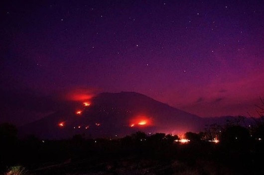 A photo posted to Instagram that appears to be fire lighting up Bali’s Mt. Agung volcano. Photo via Info Karangasem