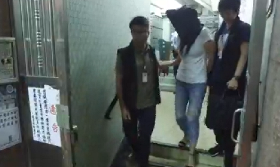 One of the defendants (C) being led away by police on Monday following her arrest. Screenshot: Hong Kong Police Force via Facebook