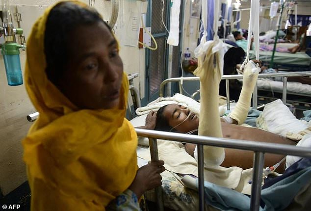 Rohingya Muslim refugee Rashida Begum (L) stands next to her son Azizul Hoque, 15, as he is treated after being injured by a landmine while crossing from Myanmar to Bangladesh, at a hospital in Cox’s Bazar. Photo: MUNIR UZ ZAMAN / AFP
