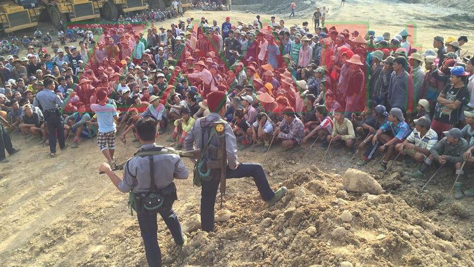 A crowd of miners gathers at the 111 mining firm’s site entrance, where they are confronted by police officers on October 8, 2017. PHOTO: Zaw Min Thet