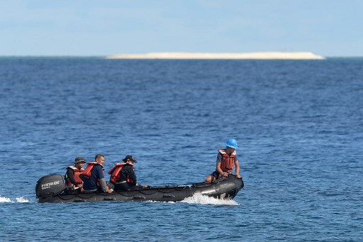 This photo taken on April 21, 2017 shows members of a Philippine survey team sailing around Philippine-held Thitu island, with a sandbar seen in the background, in the Spratlys archipelago. 
Photo by AFP/Ted Aljibe