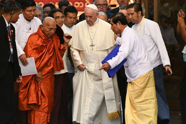 Pope Francis (R) walks with Bhaddanta Kumarabhivasma (center L), chairman of State Sanga Maha Nayaka Committee, during a meeting in Yangon on November 29, 2017. / AFP PHOTO / Vincenzo PINTO