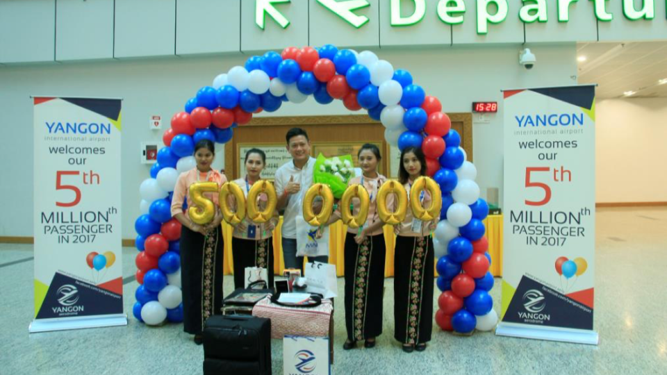 Wong Foo Cheong receives a bundle of prizes for being the five-millionth person to travel through Yangon International Airport on November 14, 2017. 