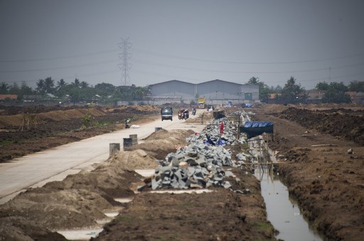 This photograph taken on October 24, 2017 shows an under-construction housing complex next to a factory which makes asbestos products in Cikarang, West Java province. AFP PHOTO / BAY ISMOYO