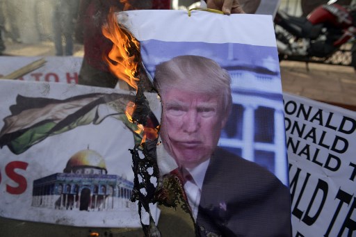 Indonesian demonstrators burn a photo featuring US President Donald Trump during a protest against US President Donald Trump’s recognition of Jerusalem as the capital of Israel, in Banda Aceh on December 10, 2017.
Trump’s move to recognise Jerusalem as Israel’s capital upended decades of American diplomacy, causing an overwhelming global diplomatic backlash and sparking Palestinian protests and clashes with Israeli security forces. / AFP PHOTO / CHAIDEER MAHYUDDIN