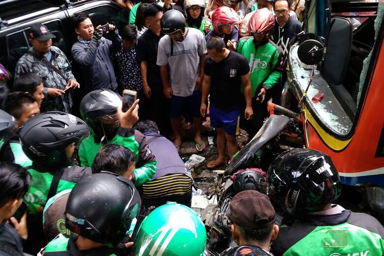 Crowd gathers at scene of accident after a Metro Mini bus crashes into and kills Go-Jek motorcycle taxi driver on December 22, 2017. Photo: South Jakarta Police