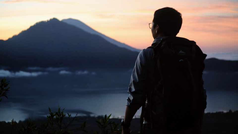 A hiker looks out over Mount Agung. Photo: Wang Dongxu/Unsplash