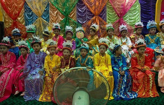 In this photo taken on March 30, 2017, young monks-to-be sit in a group as they wait to begin an elaborate parade through town during a ceremony that will see them be inducted into a monastery order in the village of Myinkabar. Photo: YE AUNG THU / AFP