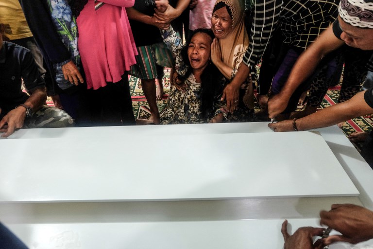 Family members of victims of a boat accident mourn in Palembang, South Sumatra province on January 5, 2018, after a boat carrying 55 people hit a large wave and sank amid bad weather.
At least 13 people died after a passenger boat capsized off the Indonesian island of Sumatra, two days after another ferry accident in the archipelago killed at least nine, police said on January 5. / AFP PHOTO / ABDUL QODIR