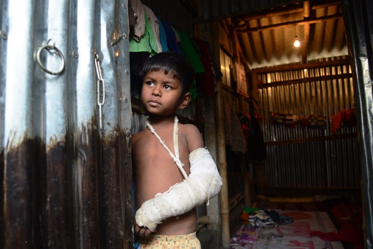 A Rohingya refugee looks out from a temporary shelter near the village of Baruipur, some 55km south of Kolkata on January 19, 2018. / AFP PHOTO / Dibyangshu SARKAR