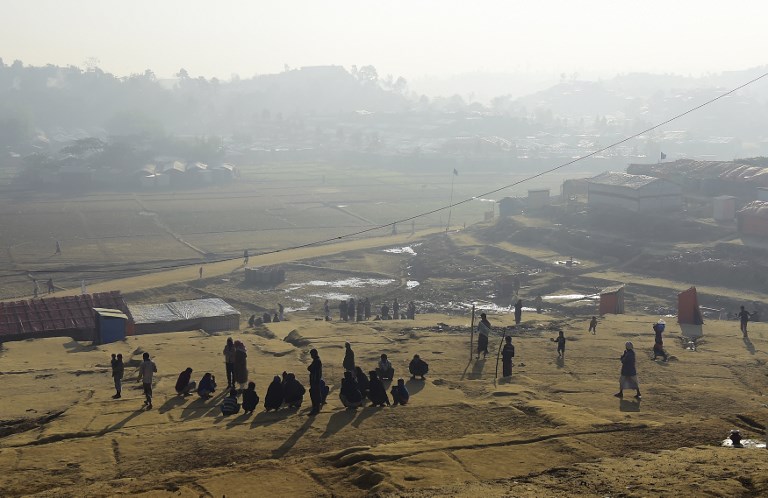 Rohingya refugee men sit together on a winter morning at Thankhali refugee camp in Bangladesh’s Ukhia district on January 22, 2018. / AFP PHOTO / Munir UZ ZAMAN