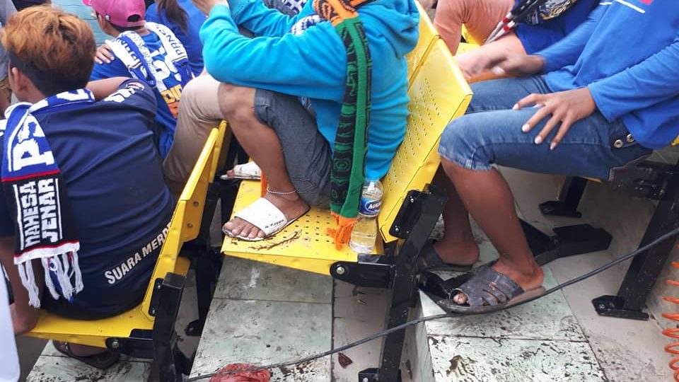 Spectators squat/sit awkwardly on the stands of Citarum Stadium in Semarang, Indonesia. Photo: Facebook/Kepareng